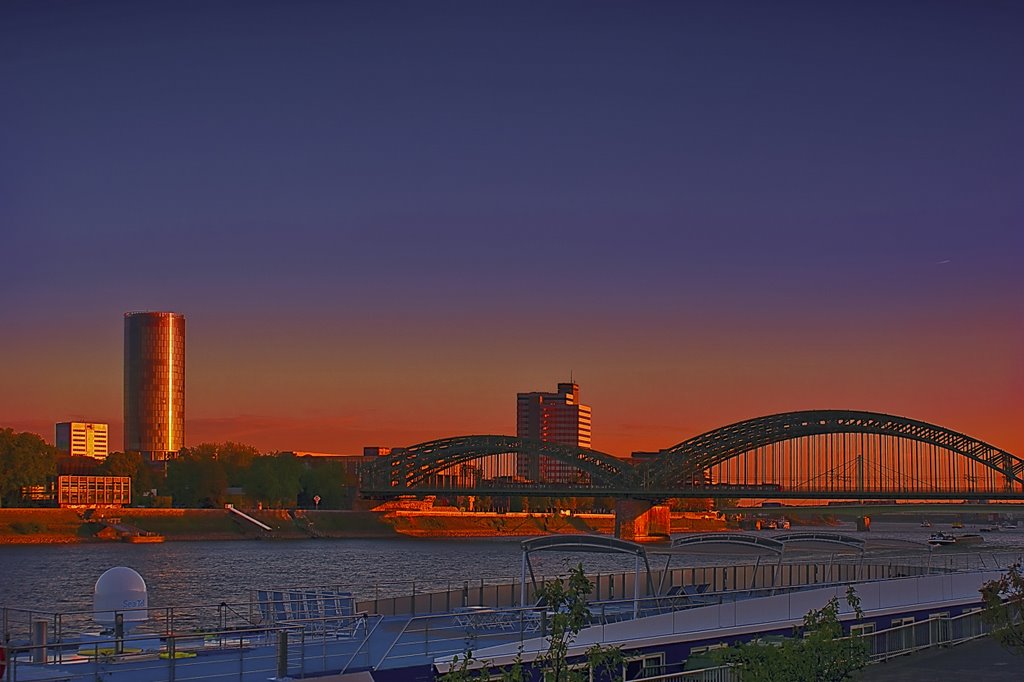 Das Köln-Triangle Hochhaus und die Hohenzollernbrücke bei Sonnenuntergang.