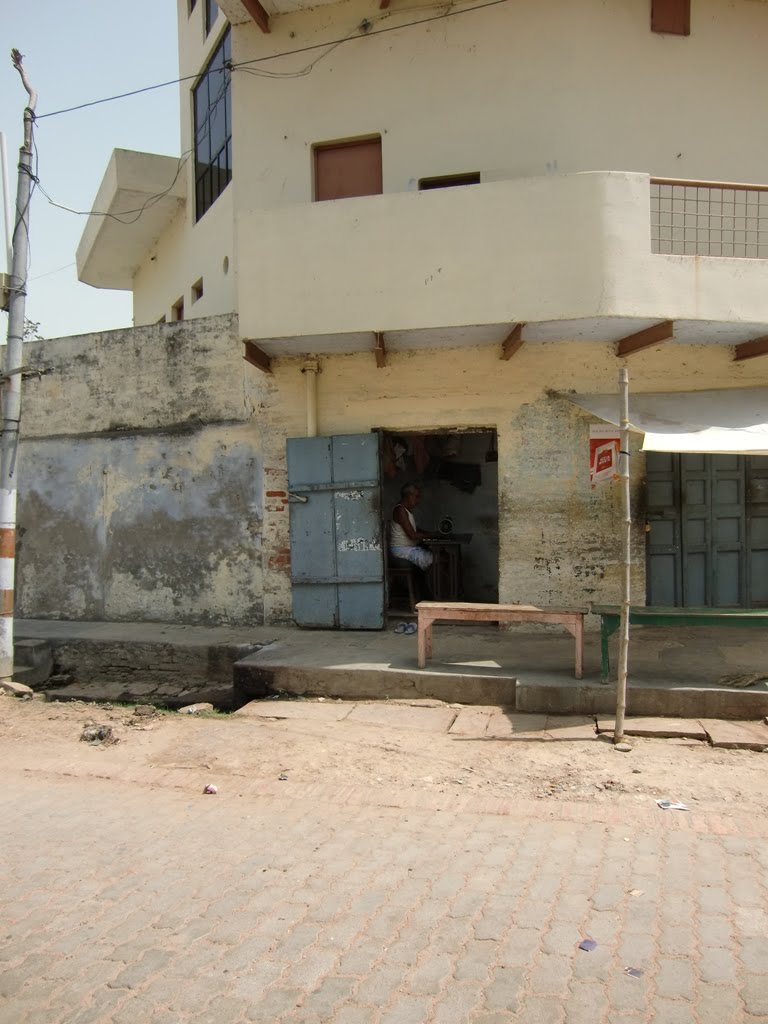 Mirzapur, a tailor at work in his small shop.