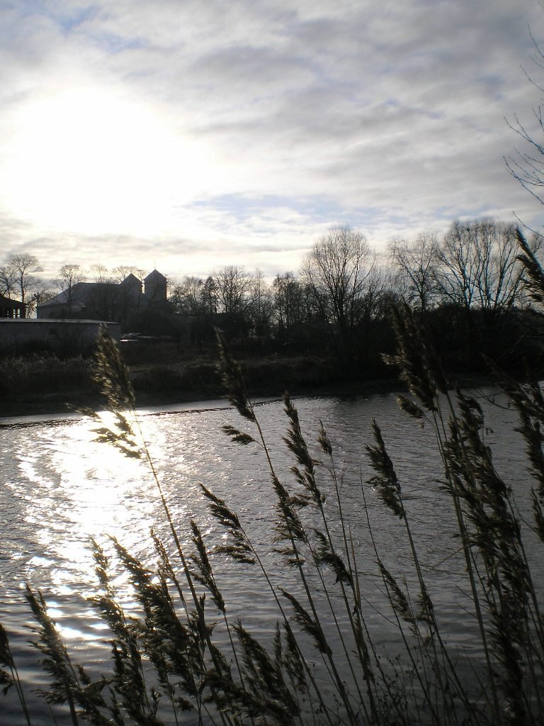 Muchavets river and catholic church in winter.