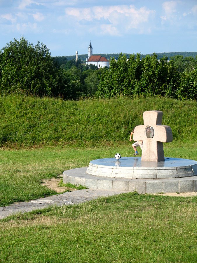 Boy playing football at the site of ancient settlement ‘Zamečak’ in Zaslaŭje. The cross in honour of 1000 years of Orthodoxy in Belarus