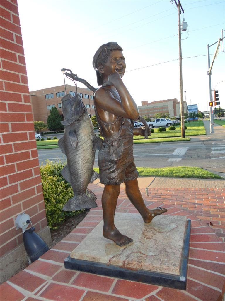 boy with big fish, Bank of Tescott parking lot, Salina, KS