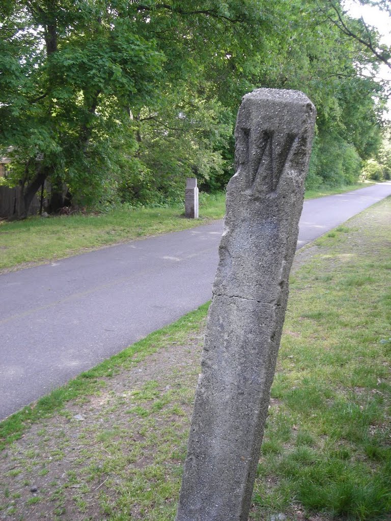 A wayside post marked "W", telling the engine driver to signal for the upcoming crossing of Mill Street in Arlington.  From my trail skating blog at http://minutemantrail.blogspot.com/2008/06/one-more-whistle-post-posting.html.
