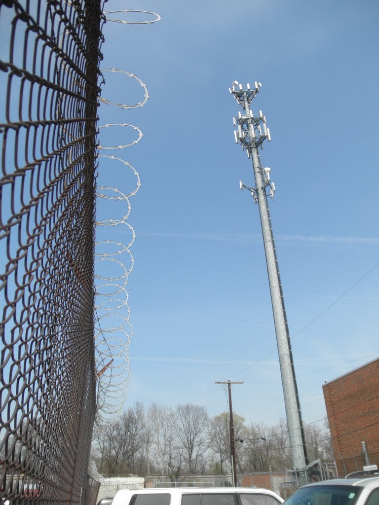 razor ribbon passing freight train and cell tower