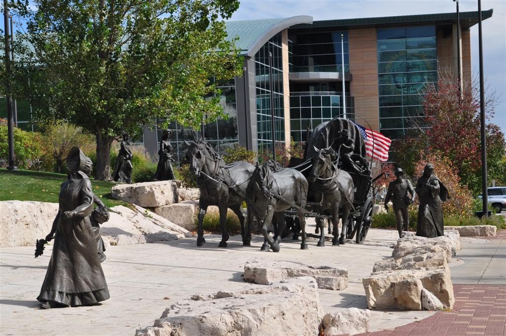 woman walking, wagon pulled by horses, Pioneer Courage, Omaha, NE