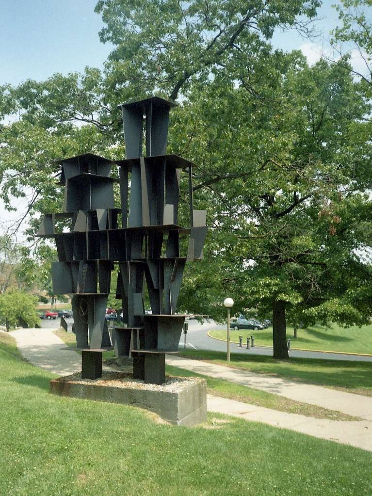 This steel sculpture carries a bullet hole from a high velocity round, near the chalked Peace symbol