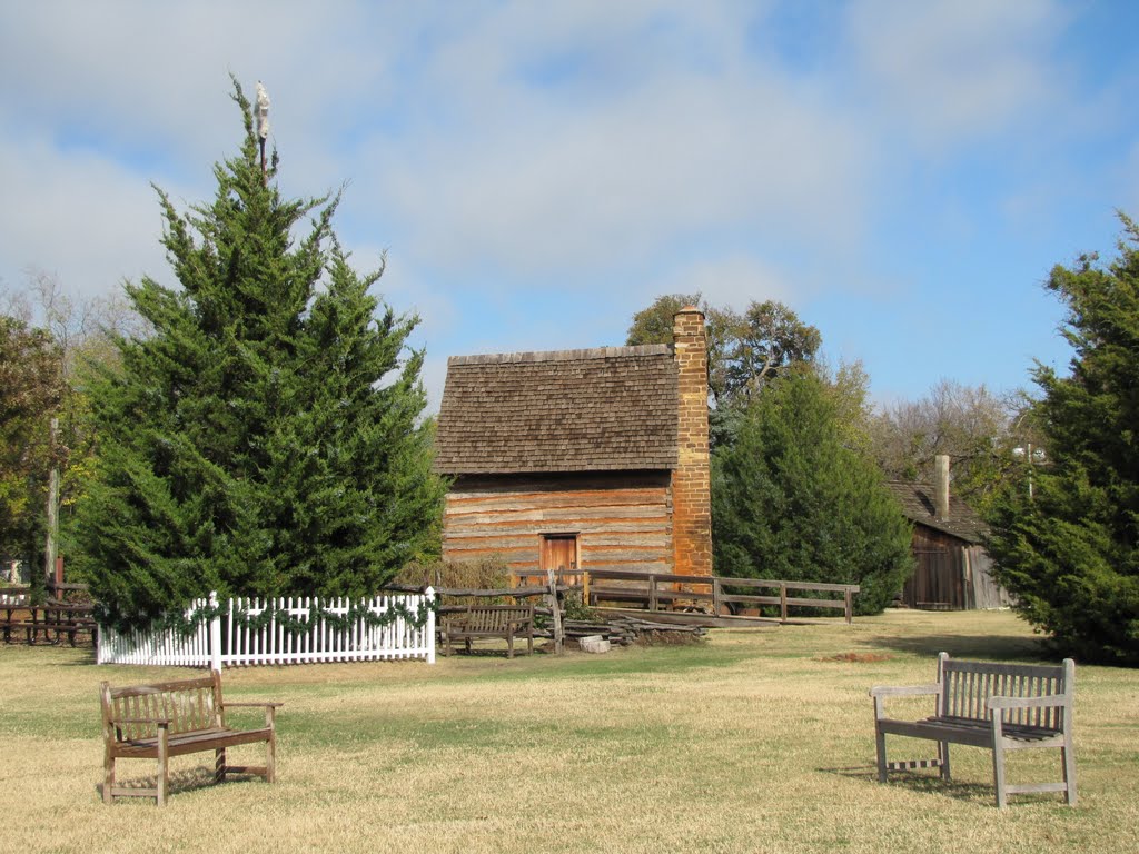 Log cabin at Farmers Branch Historical Park seen from the open field