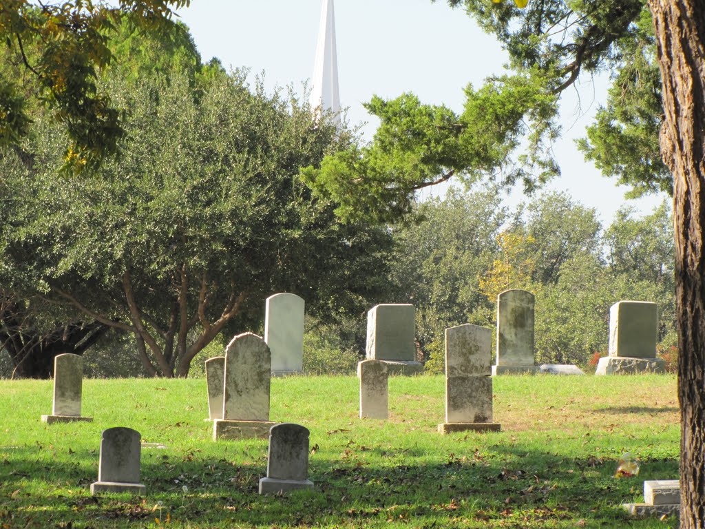 Sun-bathed grave stones at Keenan Cemetery with church steeple in the misty background