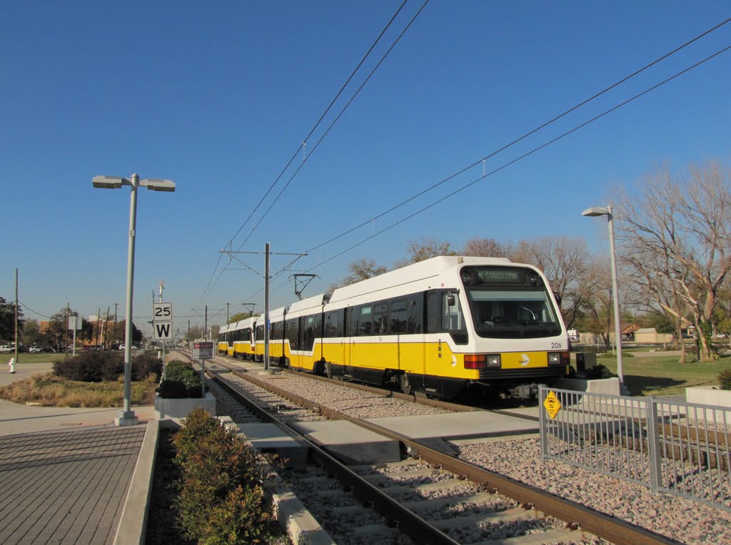 Yellow Green-line DART train in motion near Farmers Branch Station