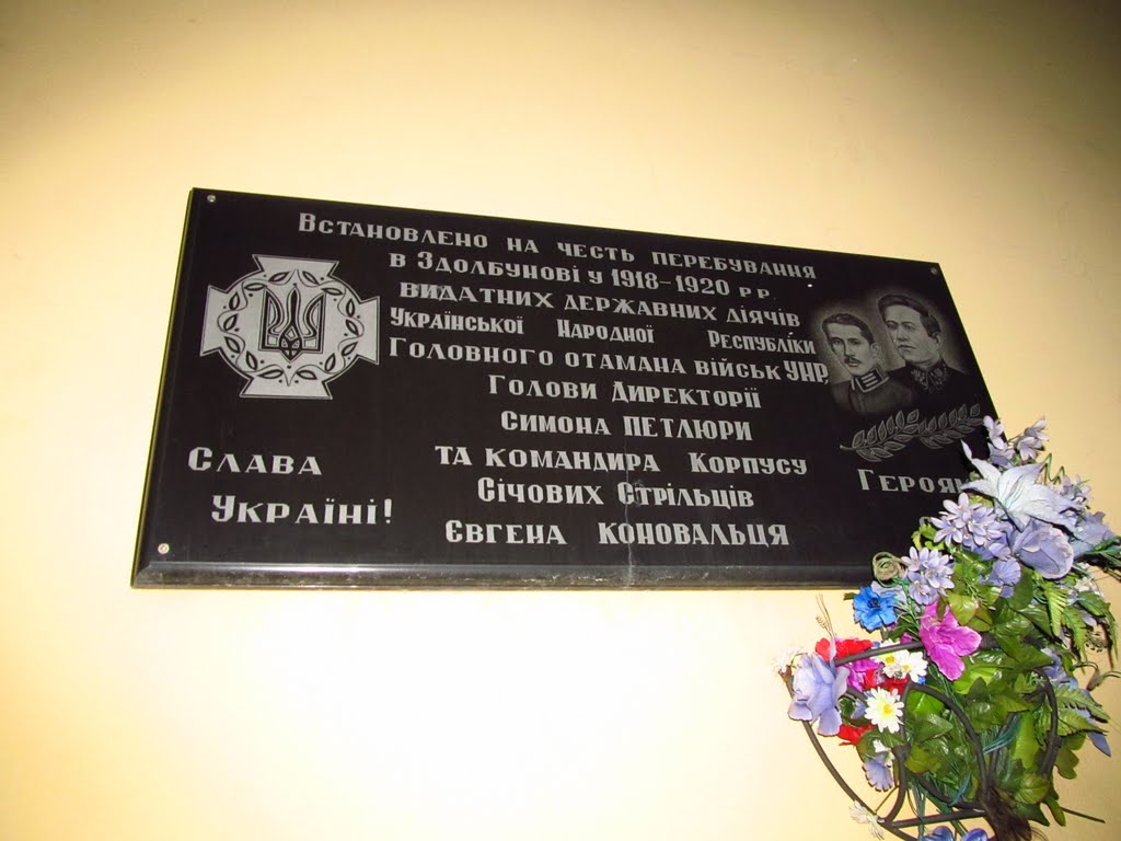 Напис на табличці залізничного вокзалу: "Слава Україні! Встановлено на честь перебування в Здолбунові у 1918 - 1920 рр видатних державних діячів Української Народної республіки Головного отамана війск УНР Голови Директорії Симона Петлюри та командира корп